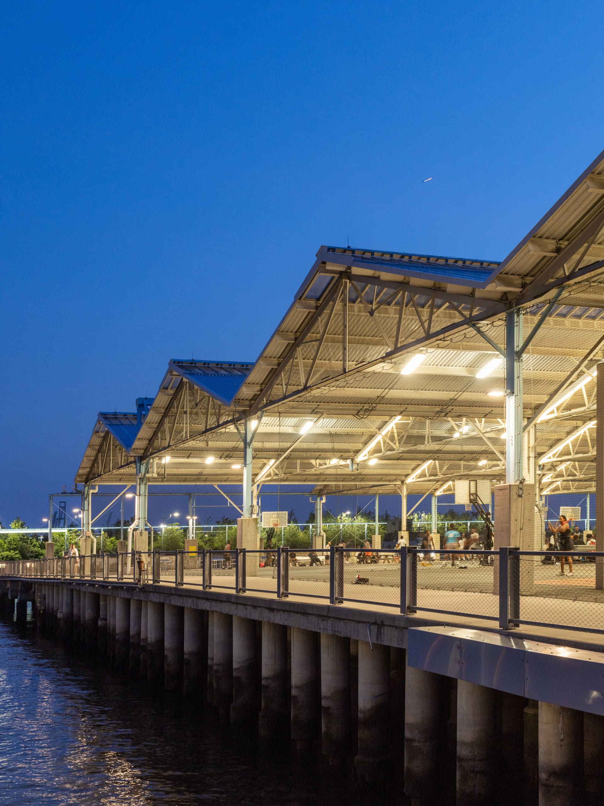 View along Pier 2 at night. Fitness area and basketball courts are seen under the roof.