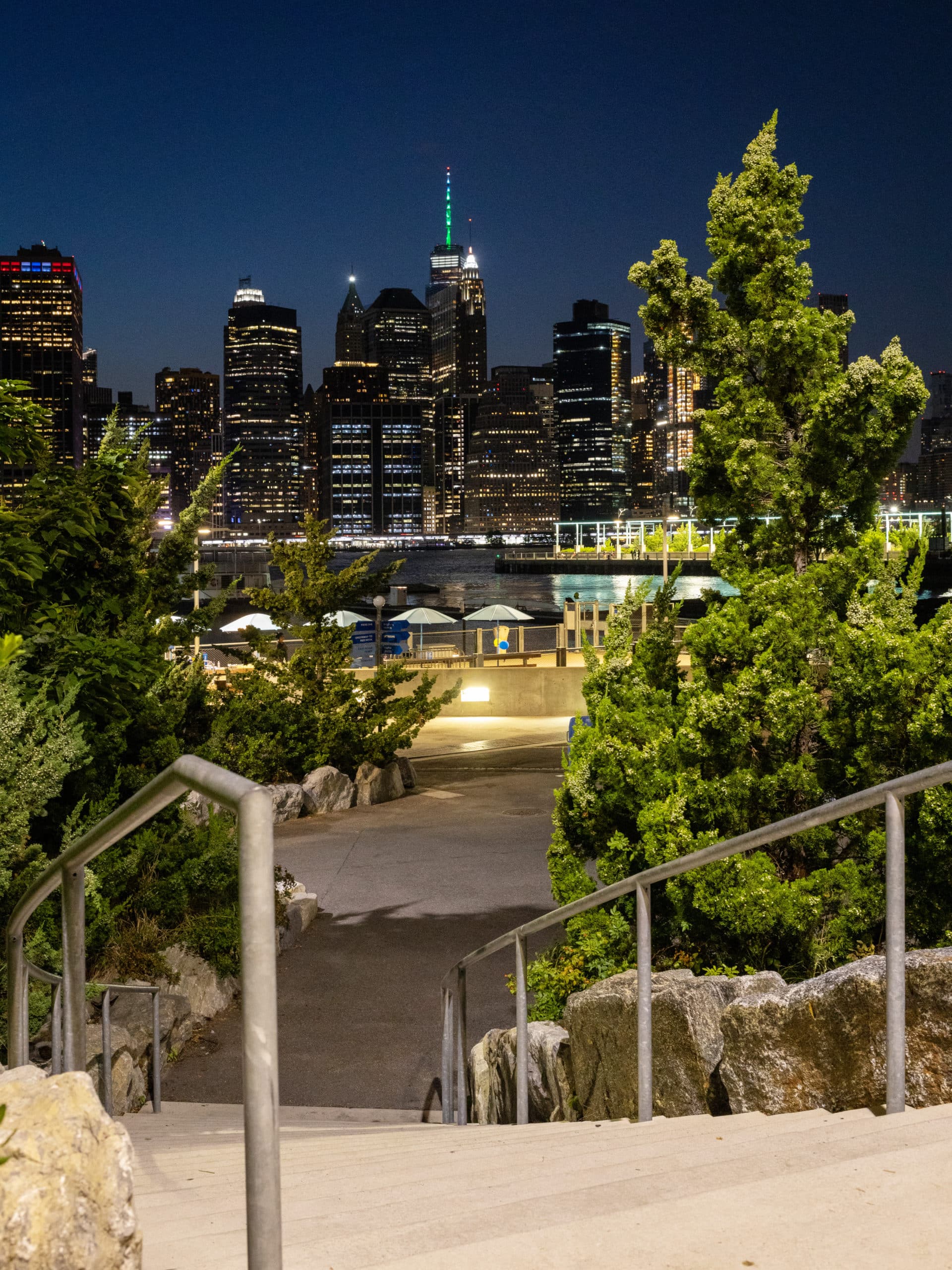 Stairs to path in Pier 5 Uplands at night with view of lower Manhattan.
