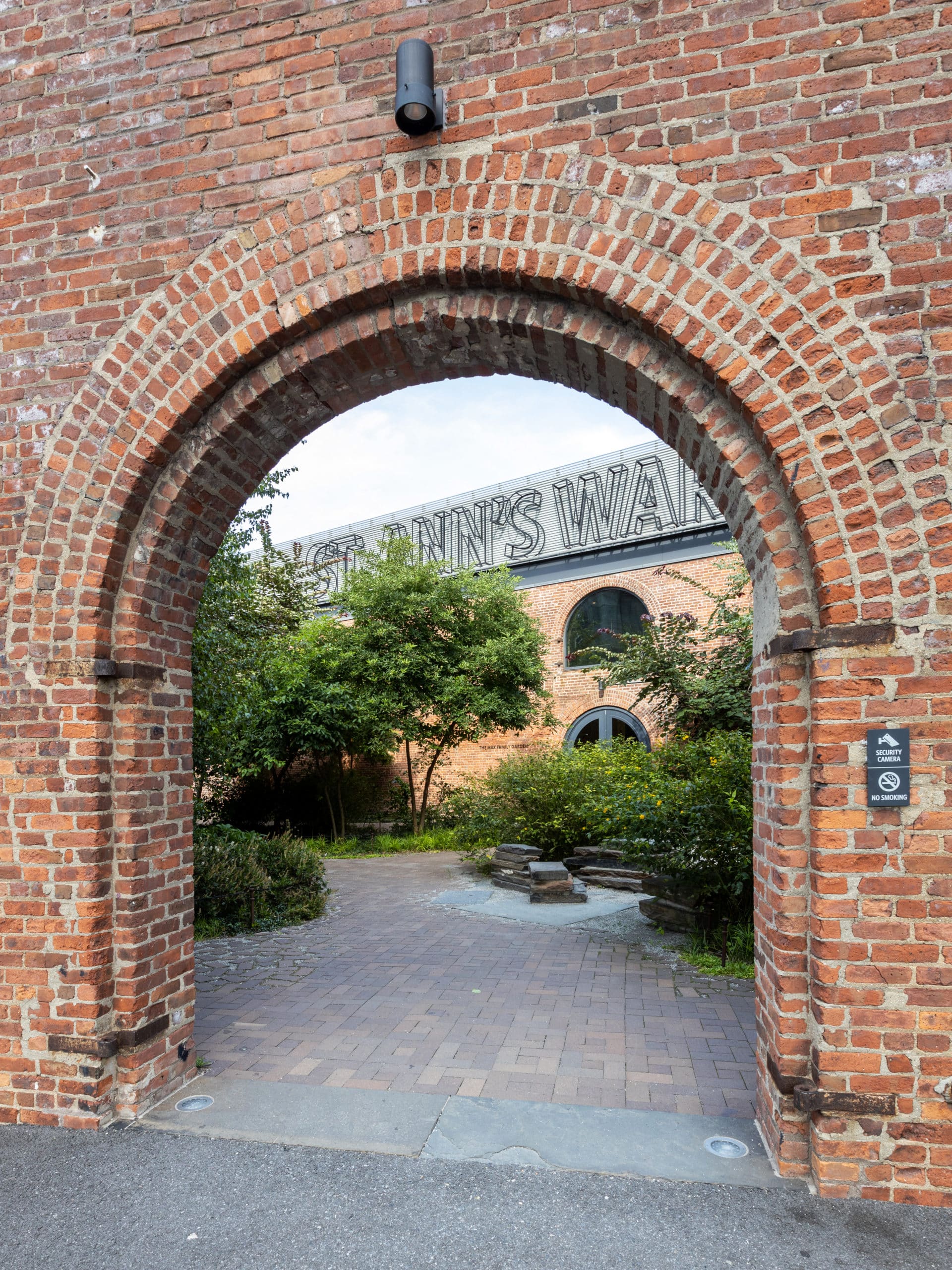Looking through brick archway to Max Family Garden. St Ann's Warehouse seen in the background.