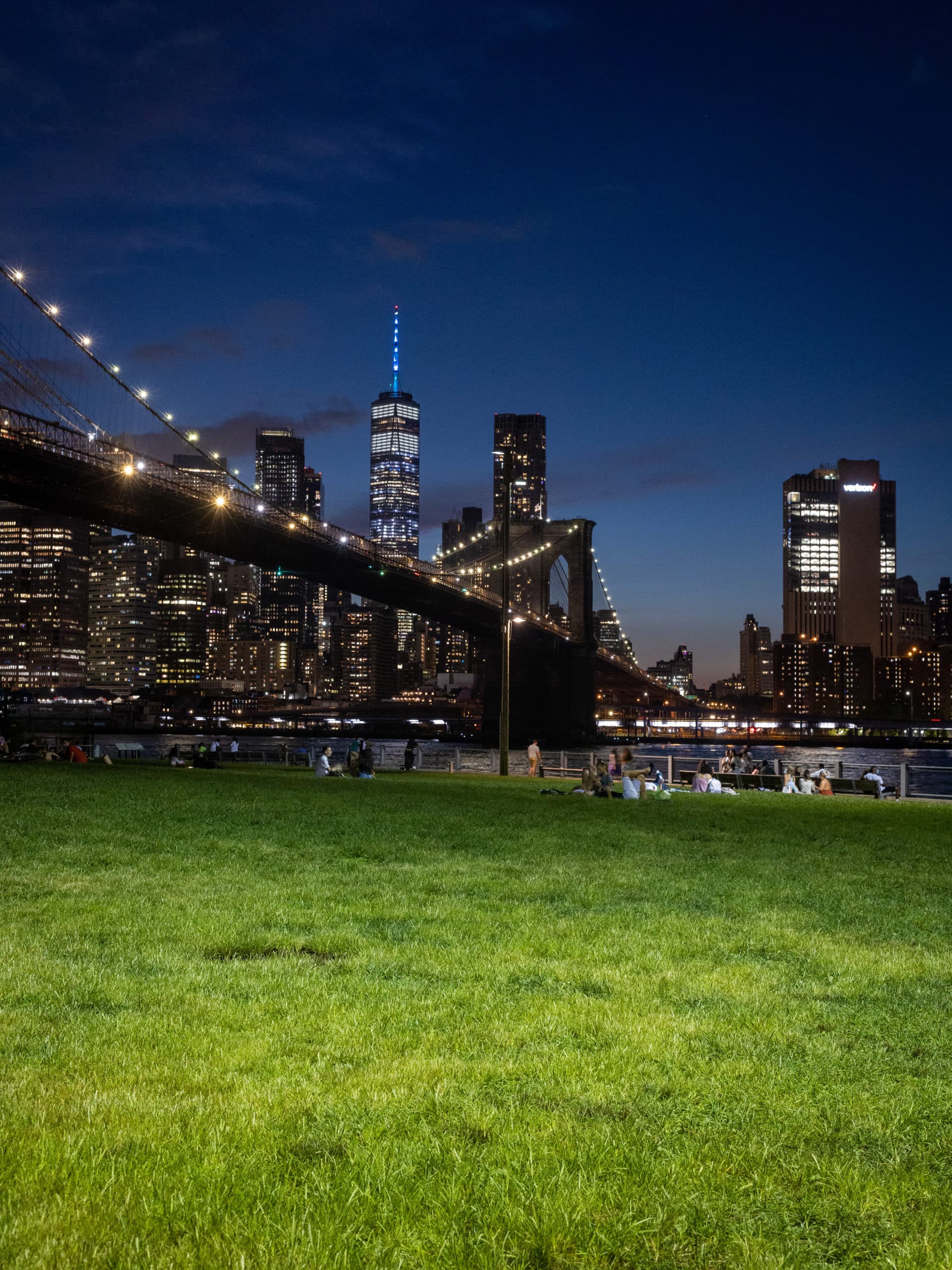 View from the Empire Fulton Ferry Lawn of the Brooklyn Bridge and lower Manhattan at night.