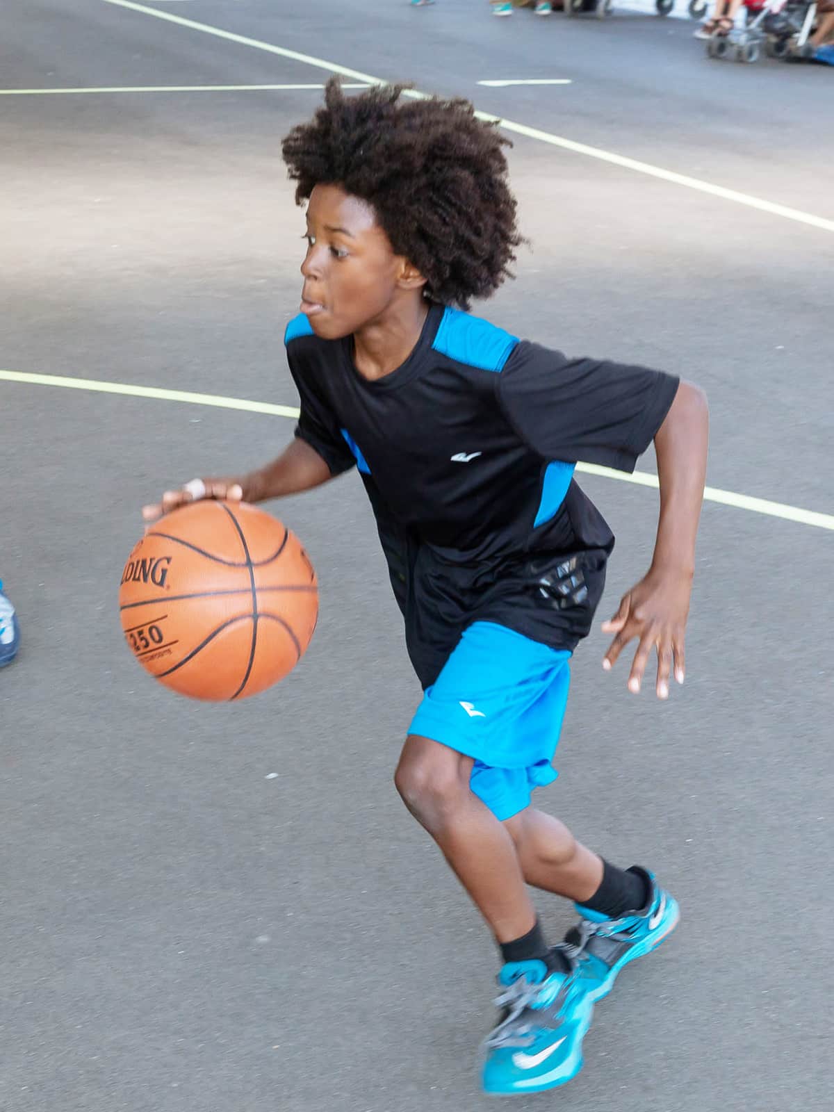 Boy running with basketball.