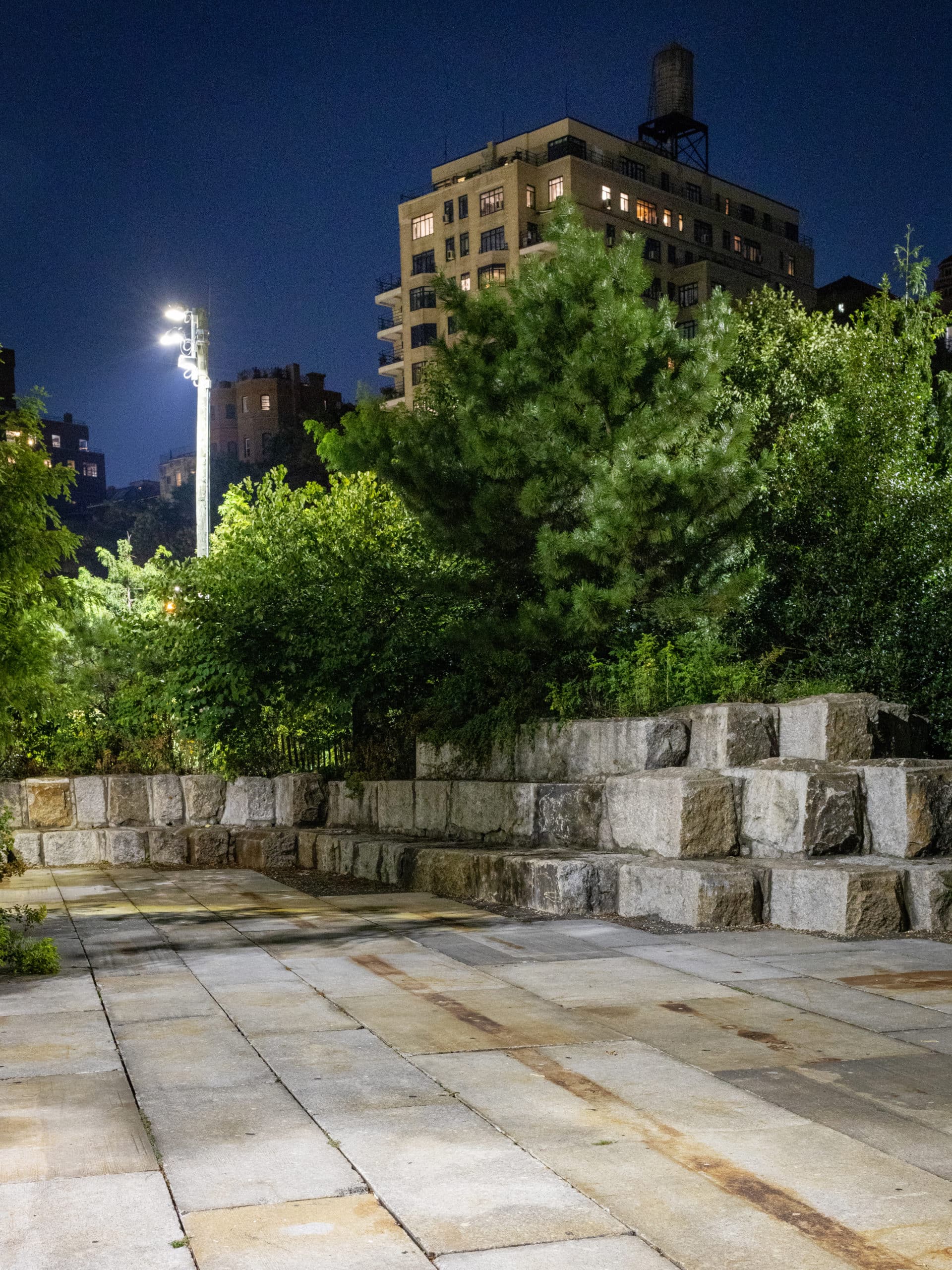 Stacked granite blocks under the trees on the Granite Terrace at night.