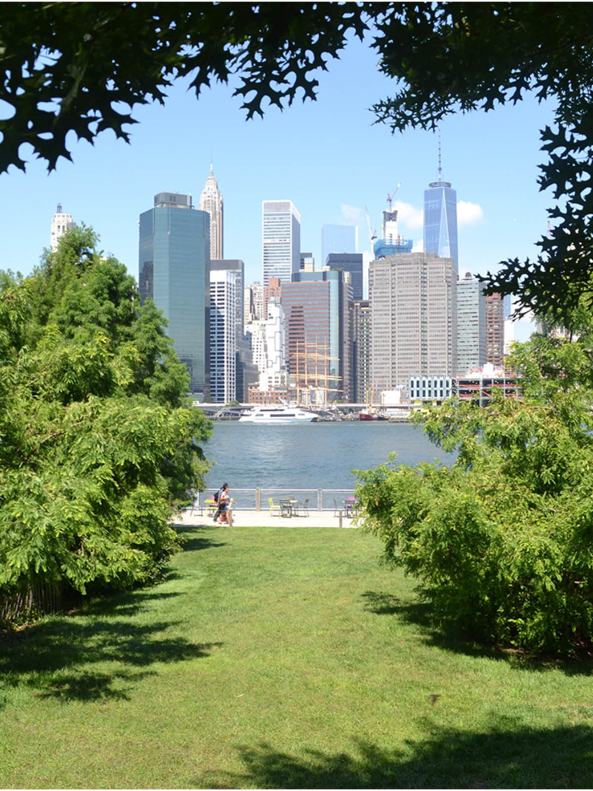 Pier 1 Lawn with a view of the promenade and lower Manhattan on a sunny day.