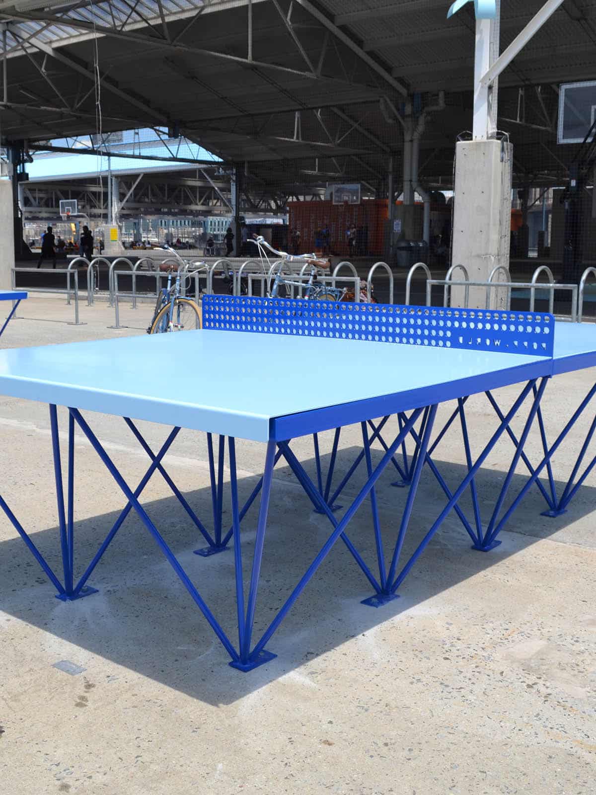 Close up of blue ping pong table on a sunny day.