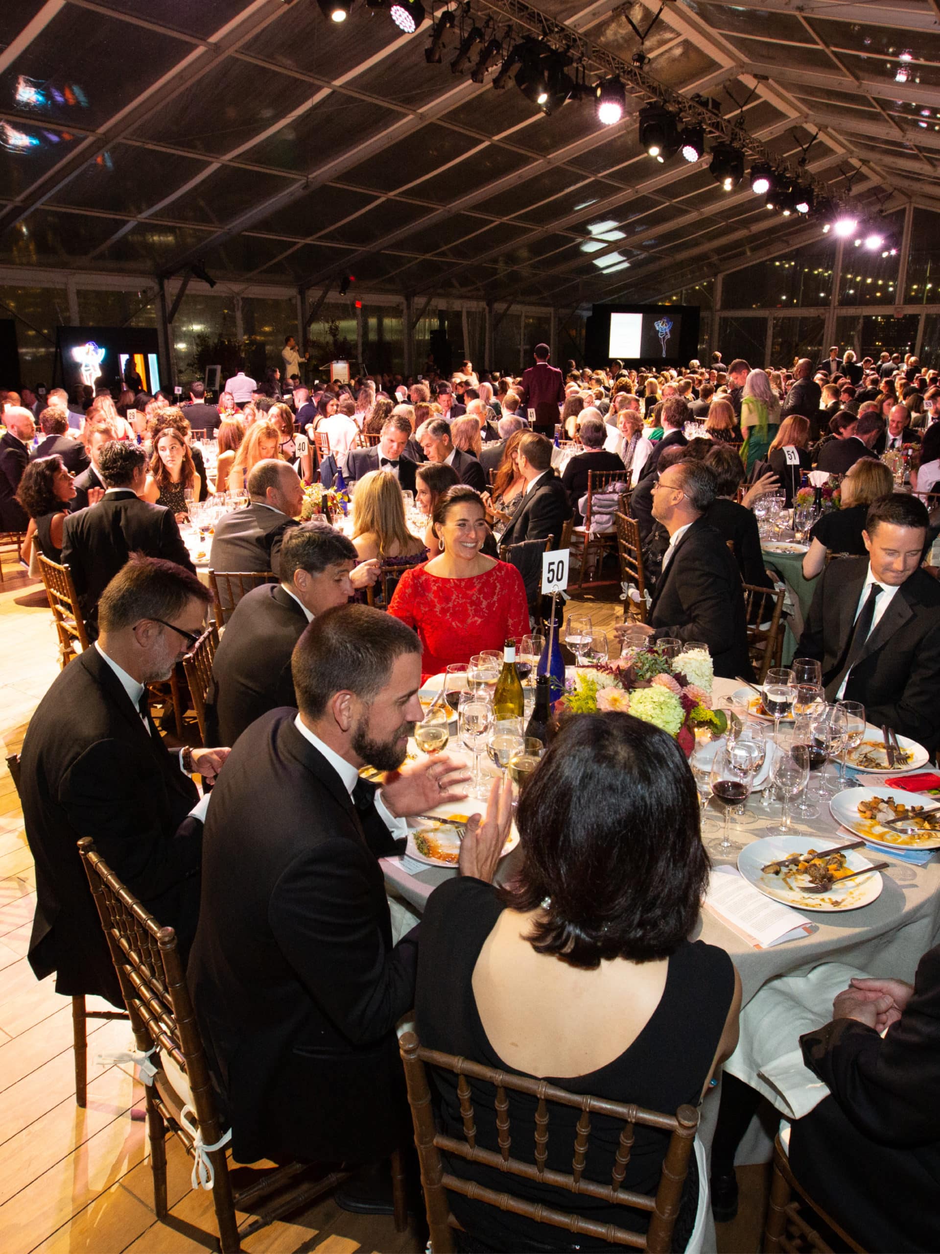 Guests sitting around tables eating at the Brooklyn Black Tie Ball