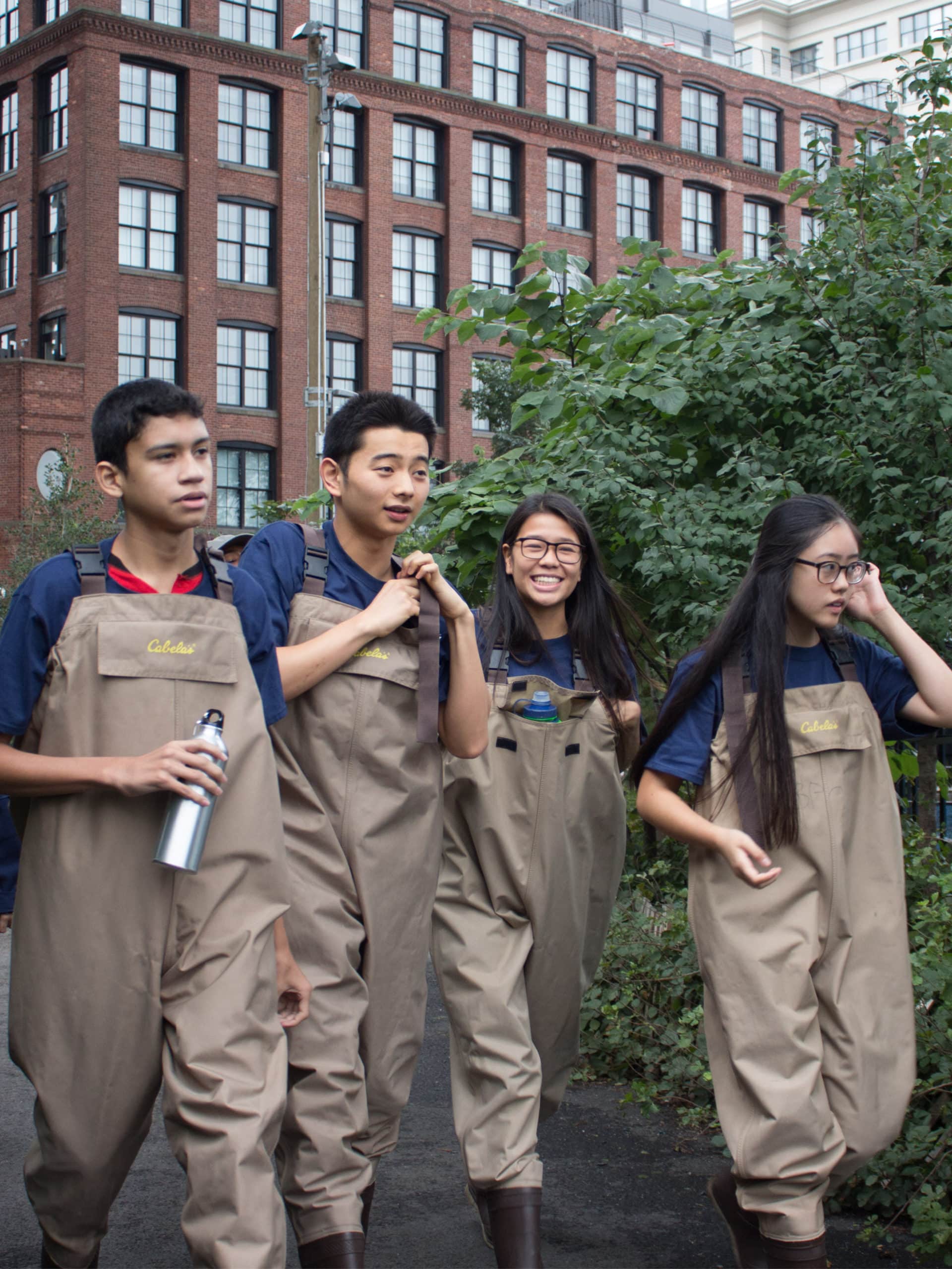 Group of teens in waders on a pathway.