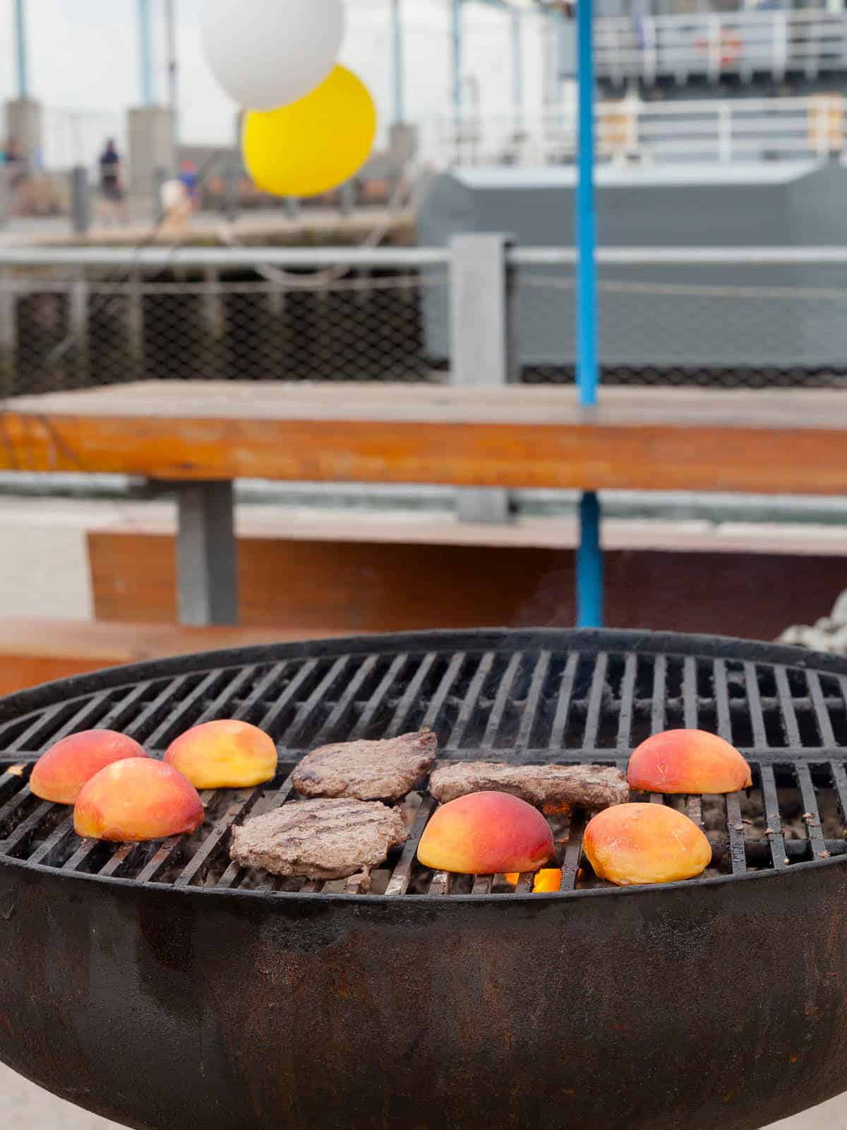 Peaches and burgers on a grill