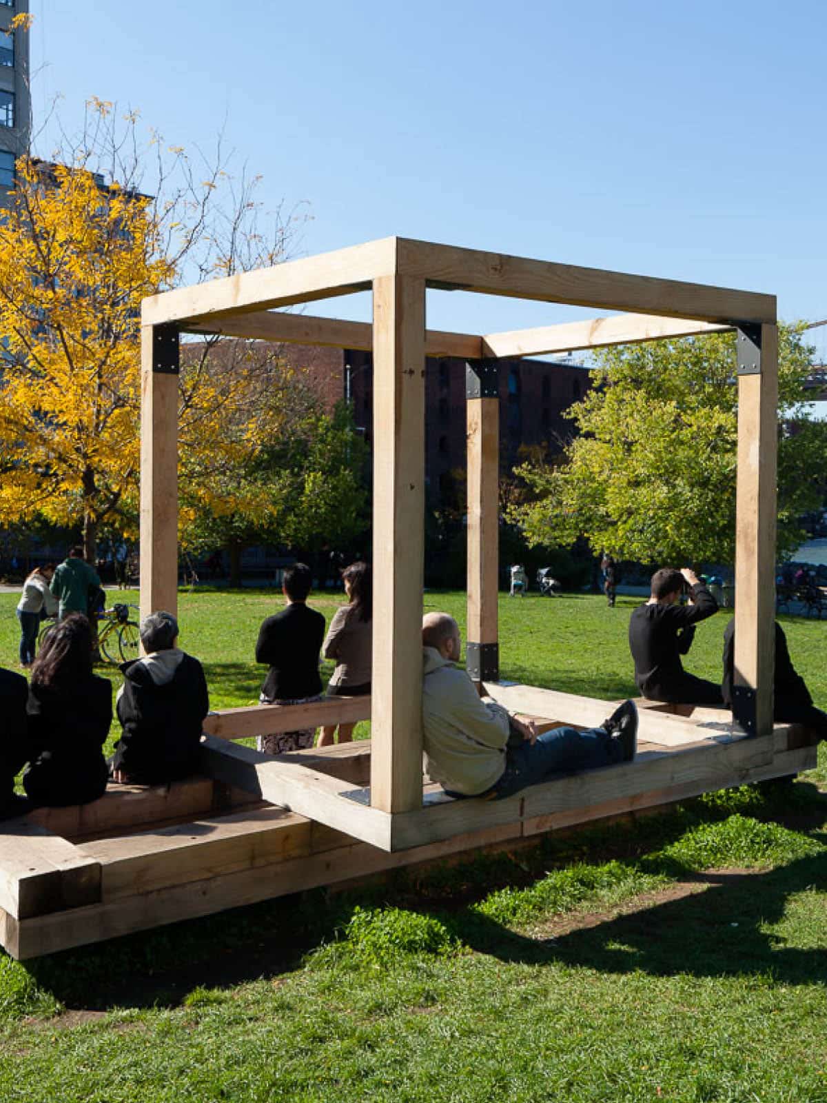 People sitting on Untitled Benches, Tables (Cube for Children) by Michael Clyde Johnson on a sunny day.